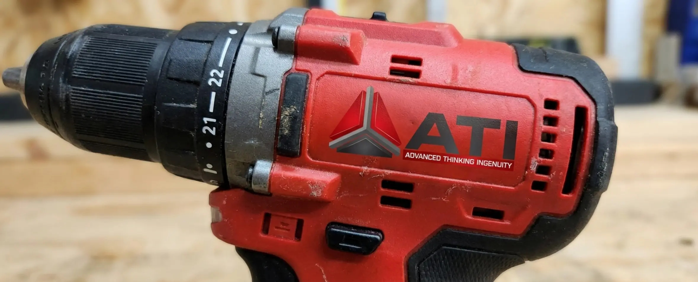 צילום תקריב איכותי של ידית מקדחה חשמלית שבה רואים בבירור את הפלסטיק הקשיח בצבע אדום ואת הגומי השחור בעל הטקסטורה שעוטף אותו באזור האחיזה